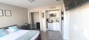 a bedroom with a bed and a small kitchen at Studio University Pines at Sarasota in Sarasota