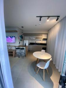 uma sala de estar e cozinha com mesa e cadeiras em Flat Diamond 908 em São Lourenço