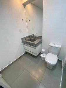 uma casa de banho branca com um WC e um lavatório em Flat Diamond 908 em São Lourenço
