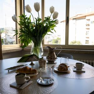 a table with a vase of flowers and food on it at CENTER BOUTIQUE HOME SUL FIUME in Ascoli Piceno +12 photos