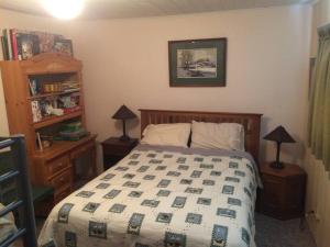 1 dormitorio con 1 cama, 2 lámparas y estante en River House in Welches on Mt Hood OR, en Welches