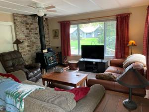 sala de estar con sofá y TV en River House in Welches on Mt Hood OR, en Welches