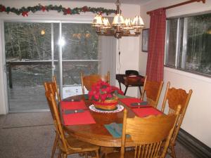 comedor con mesa de madera y servilletas rojas en River House in Welches on Mt Hood OR, en Welches