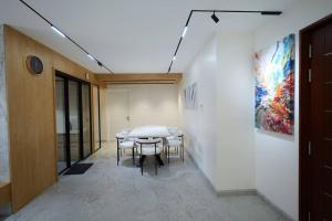 a table and chairs in a room with a painting at The Nova Heights in Kozhikode