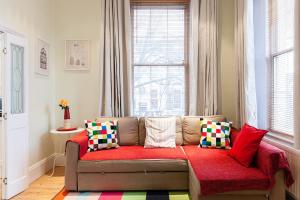 a couch sitting in a living room with a window at Stunning Bright flat in London