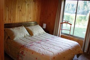 a bedroom with a bed with a large window at Cabañas Buenavista Quillón in Quillón