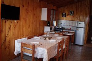 y cocina con mesa, sillas y nevera. en Cabañas Buenavista Quillón en Quillón