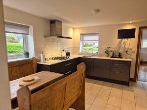 a kitchen with a sink and a table in it at Poplars Cottage in Usk
