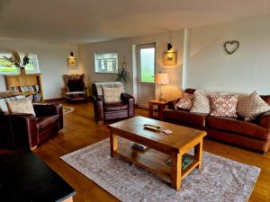 a living room with couches and a coffee table at Poplars Cottage in Usk