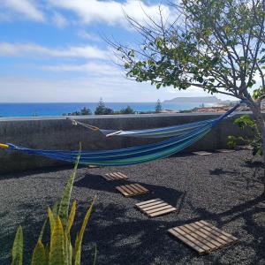 a blue hammock sitting on the ground next to a tree at Villa Bella Mar by Madeira Sun Travel in Porto Santo