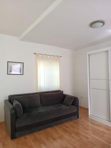a living room with a black couch in a room at Apartment Udovičić Center in Vodice