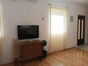 a living room with a flat screen tv on a dresser at Apartment Udovičić Center in Vodice