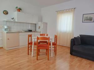a living room with a table and chairs and a couch at Apartment Udovičić Center in Vodice