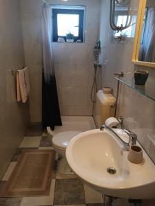 a bathroom with a white sink and a toilet at Apartment Udovičić Center in Vodice +1 photo