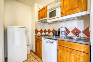 a small kitchen with a sink and a refrigerator at Montenvers furnished flat in Chamonix