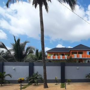 una casa con palmeras delante en Château angele w&b, en Lomé