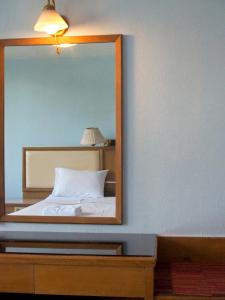 a mirror on top of a bed in a room at Wish Inn Chidlom - วิช อินน์ ชิดลม in Makkasan