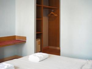 a bedroom with a white bed and a closet at Wish Inn Chidlom - วิช อินน์ ชิดลม in Makkasan