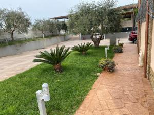 een gazon met planten en bomen en een gebouw bij Miro' Agropoli in Agropoli