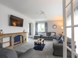 a living room with couches and a fireplace at Bwthyn Y Bae in Holyhead