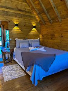 sypialnia z łóżkiem w drewnianym pokoju w obiekcie Pousada Refúgio dos Canyons w mieście Praia Grande