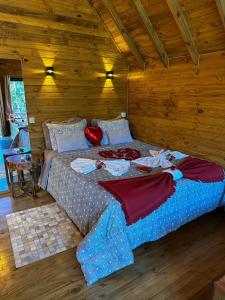sypialnia z dużym łóżkiem w drewnianym pokoju w obiekcie Pousada Refúgio dos Canyons w mieście Praia Grande