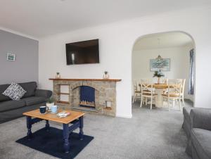 a living room with a fireplace and a table at Bwthyn Y Bae in Holyhead