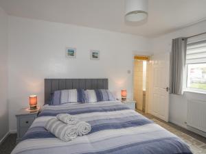 1 dormitorio con 1 cama con toallas en Bwthyn Y Bae, en Holyhead