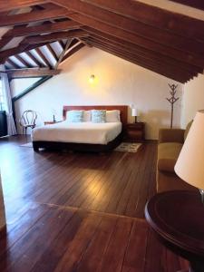 a bedroom with a bed and a couch in a room at Hacienda El Novillero in Fusagasuga