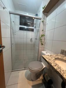 uma casa de banho com um chuveiro, um WC e um lavatório. em Apartamento aconchegante em Betim em Betim
