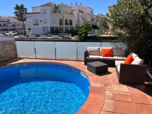 a swimming pool with a couch and a chair next to at Villa Empuriabrava on main canal with 13 m private mooring, private pool, air con in all rooms, non-smoking in Empuriabrava