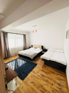 two beds in a room with wooden floors at DAS home-Apartament cu vedere la munte in Râşnov