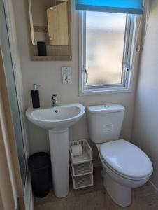 La salle de bains est pourvue d'un lavabo, de toilettes et d'une fenêtre. dans l'établissement Abi the Sand castle, à Port Seton