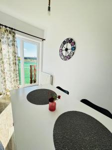 una habitación con una mesa y un reloj en la pared en DAS home-Apartament cu vedere la munte en Rîşnov