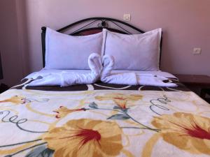 ein Bett mit zwei Kissen mit zwei Herzen darauf in der Unterkunft SEVEN DAYS HOTEL in Toufleht