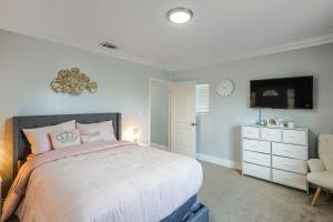 a bedroom with a bed and a chair and a clock at South Central LA Home with Patio 11 Mi to Ocean! in Compton
