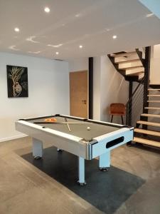 a pool table in a room with a staircase at Le Dormadou des tilleuls in Graveson