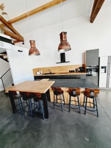 a kitchen with a wooden table and stools at Le Dormadou des tilleuls in Graveson