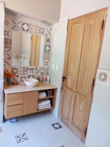 La salle de bains est pourvue d'une porte en bois et d'un lavabo. dans l'établissement La Casona, à Cafayate