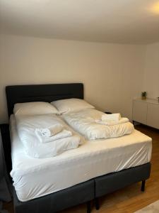 a bed with white sheets and towels on it at Zentrale Wohnung Gmunden Alte Bäckerei in Gmunden