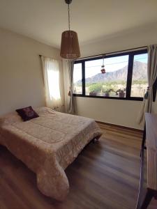 - une chambre avec un lit et une grande fenêtre dans l'établissement La Casona, à Cafayate