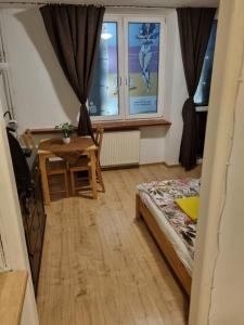 1 dormitorio con cama, mesa y ventana en Kwatera na Wspólnej, en Varsovia