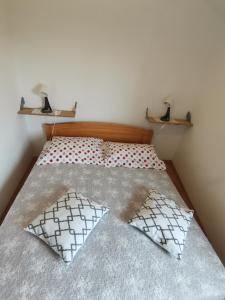 een bed met 2 kussens in een kleine slaapkamer bij Apartment N&M (Natasa and Milan) in Omišalj