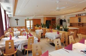 a restaurant with tables and chairs and a cross on the wall at Gasthof Stern in Prato allo Stelvio