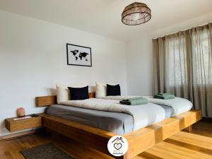 1 dormitorio con 1 cama grande con marco de madera en Family M Apartments 7 en Sempach