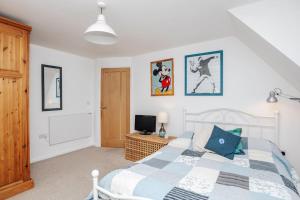 a bedroom with a bed and a tv in it at TheTulips- 4 bed, Henley Regatta in Henley on Thames