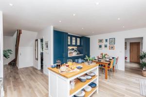 a kitchen and dining room with blue cabinets and a table at TheTulips- 4 bed, Henley Regatta in Henley on Thames