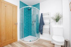 a bathroom with a shower with blue tile at TheTulips- 4 bed, Henley Regatta in Henley on Thames