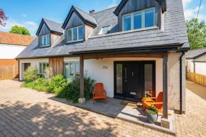 a house with two orange chairs on a patio at TheTulips- 4 bed, Henley Regatta in Henley on Thames