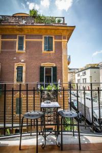 羅馬的住宿－聖彼得羅休閒豪華旅館，阳台配有2张桌子和2把凳子